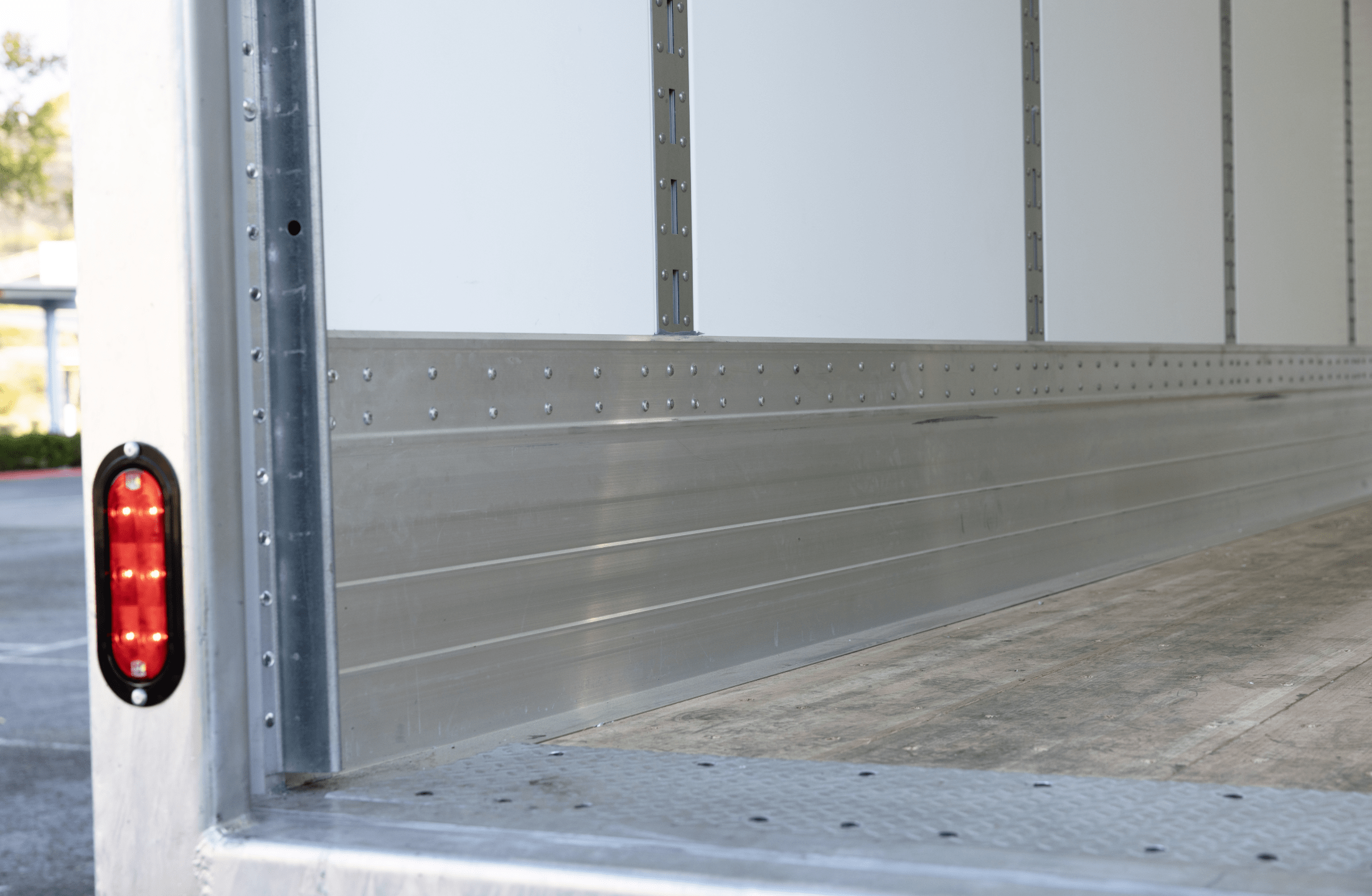 Interior lower section of a Hyundai Translead Anza truck body, showcasing the durable kick plate, floor, and rear lighting, reflecting Hyundai's truck body technology and quality.